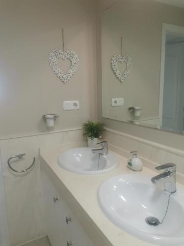 a white bathroom with two sinks and a mirror at Mi Capricho in Sitio de Calahonda