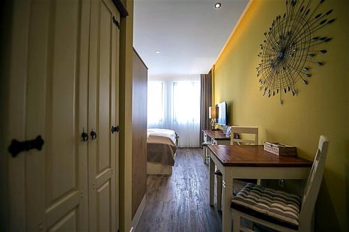 a room with a bedroom with a bed and a desk at Hotel Apartment Central Leipzig-City & Zoo in Leipzig