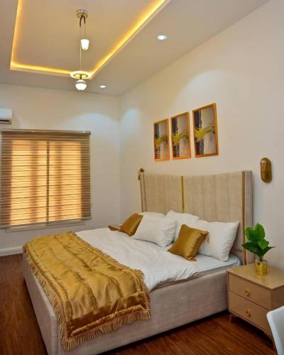 a bedroom with a large bed with white sheets and pillows at TM Homes in Abuja