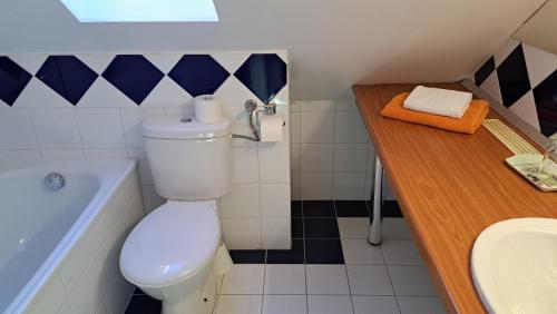 a bathroom with a toilet and a sink and a tub at Platán Hotel in Sárvár