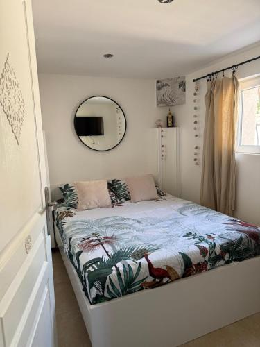 a small bedroom with a bed with a mirror at Superbe T2 au rez-de-chaussée avec jardin in Arles