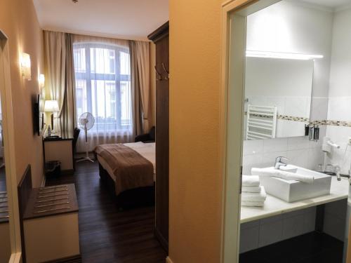 a hotel room with a sink and a bed at Fründts Hotel in Wismar