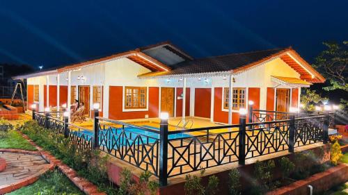a house with a large deck in front of it at Snehdeep Villa, Konkan Trail in Dapoli