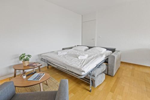 a bed in a room with a couch and a table at Appartement central et confortable in Crans-Montana