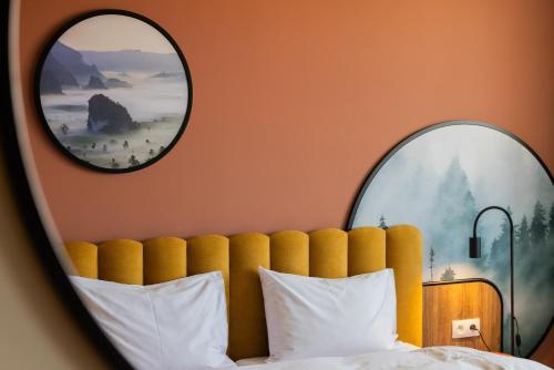 a bedroom with two mirrors above a bed at Santa Christina Mountain Resort in Świeradów-Zdrój