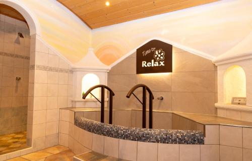a bathtub in a bathroom with a sign on the wall at Alpenperle in Ramsau am Dachstein
