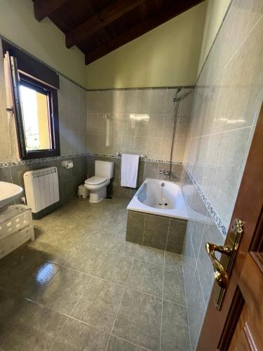 a bathroom with a tub and a toilet and a sink at Gestiona2R - Casa Dos Carmenes, caminando a la playa, ideal familias in Llanes