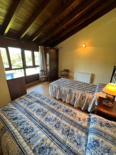 two beds sitting in a room with windows at Gestiona2R - Casa Dos Carmenes, caminando a la playa, ideal familias in Llanes