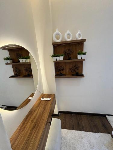 a room with wooden shelves and white vases on the wall at Rent house b8 in Madinaty