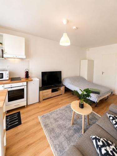 a small living room with a couch and a kitchen at Superbe studio proche Disney in Champs-sur-Marne