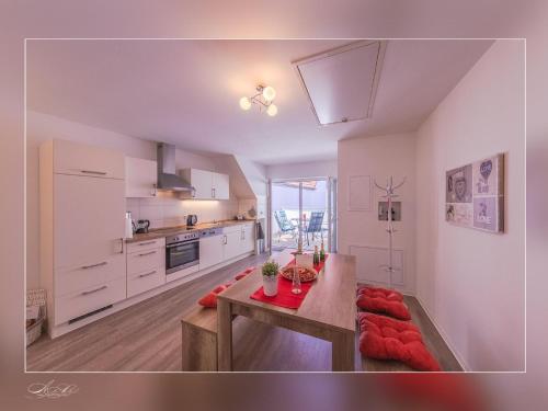 a kitchen with white cabinets and a table in it at Fewo Müritzfrische 2 in Waren