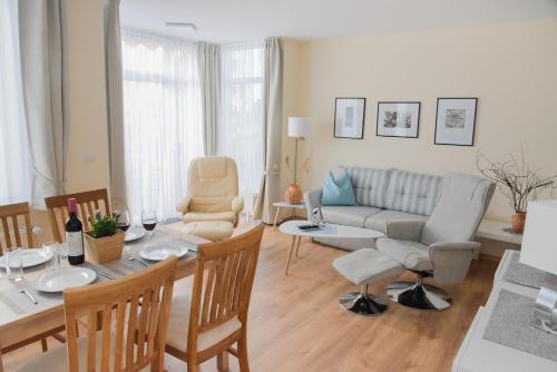 a living room with a couch and a table and chairs at Am Seeufer 59 Fewo 1 in Waren
