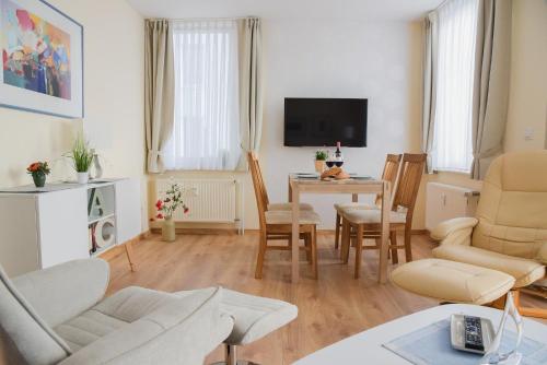a living room with a table and chairs and a television at Am Seeufer 59 Fewo 1 in Waren