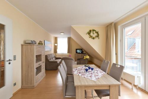 a dining room and living room with a table and chairs at Am Seeufer 60 Fewo 605 in Waren