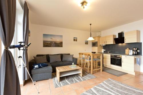 a living room with a couch and a kitchen at Haus am Kölpinsee App 3 3 in Waren