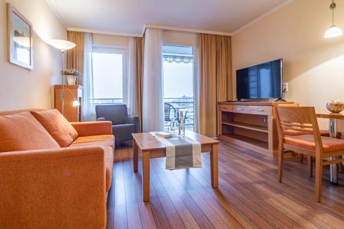 a living room with a couch and a television at Hafendomicil Appartement WH12 - Specht in Waren