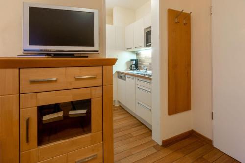 a kitchen with a television on top of a dresser at Hafendomicil Appartement WH04 - Igel in Waren