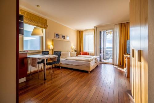 a hotel room with a bed and a desk and a table at Hafendomicil Appartement WH11 - Eichhörnchen in Waren