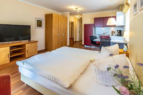 a bedroom with a large bed and a kitchen at Hafendomicil Appartement WH11 - Eichhörnchen in Waren