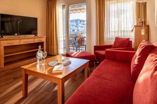 a living room with a red couch and a table at Hafendomicil Appartement WH13 - Eisvogel in Waren