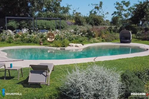 a small swimming pool in a yard with two chairs at Villa Pietrarosa by MMega in Cascina Monte Serico