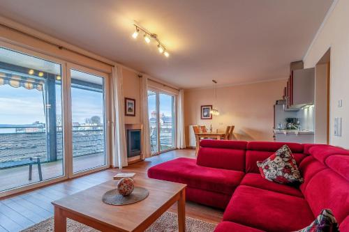 a living room with a red couch and a table at Hafendomicil Appartement WH15 - Adler in Waren