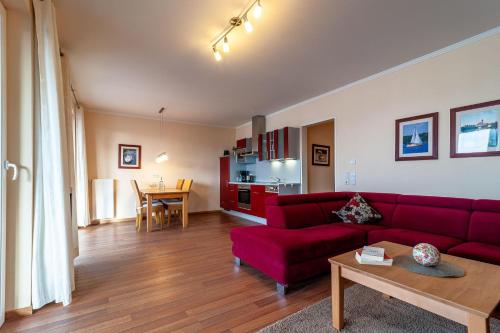 a living room with a red couch and a table at Hafendomicil Appartement WH15 - Adler in Waren