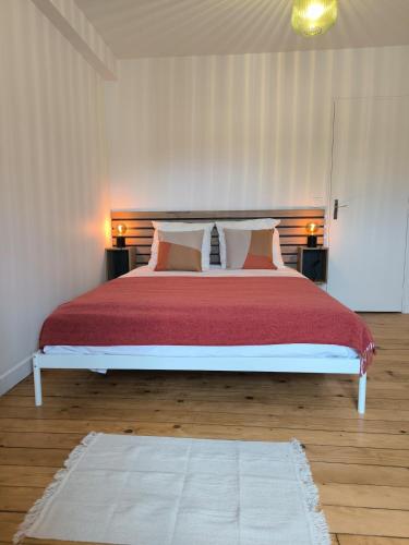 a bedroom with a large bed with red sheets and pillows at Hyper Centre Beauvais Cosy Appartement in Beauvais