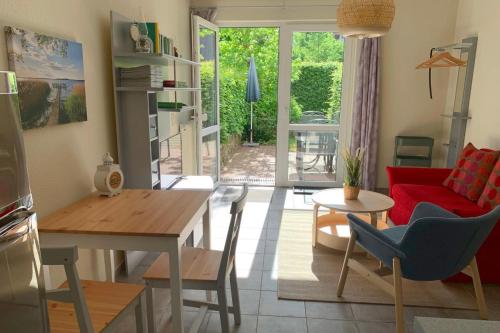 a living room with a table and a red couch at UG-Birke in Göhren-Lebbin
