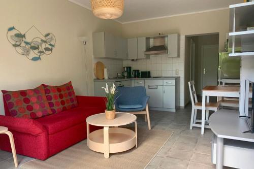 a living room with a red couch and a table at UG-Birke in Göhren-Lebbin