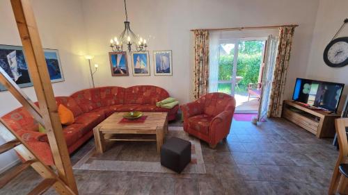 a living room with a red couch and a table at Ferienhaus Jabel 30 in Jabel