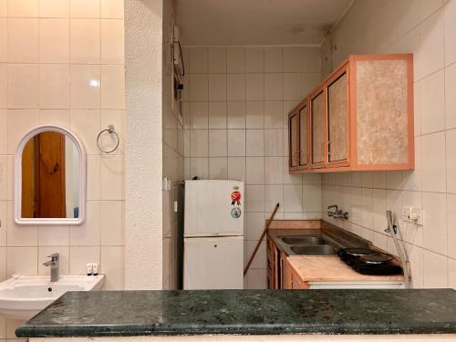 a kitchen with a sink and a white refrigerator at الكرامة للشقق المفروشة in Abha