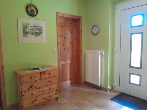 a room with a door and a dresser and a clock at Tannenblick Loppin EG in Jabel