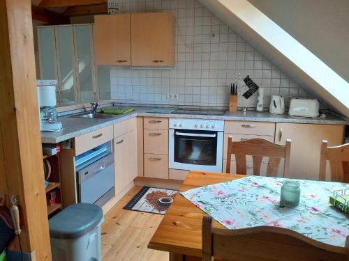 a kitchen with a table and a sink and a stove at Tannenblick Loppin DG in Jabel
