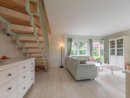 a living room with a staircase and a couch at Kornblume_DH in Röbel