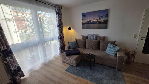 a living room with a couch and a large window at WarenERleben in Waren