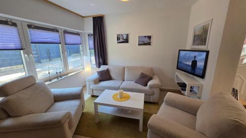 a living room with couches and a tv at Ferienhaus Wennmann in Waren