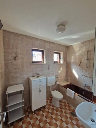 a bathroom with a toilet and a sink and a tub at Hotel Stara šola - Oleander Resort in Izola