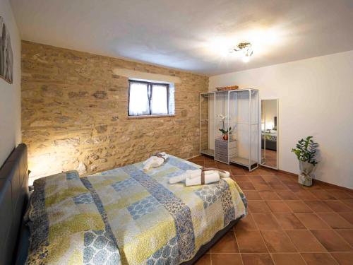 a bedroom with a bed and a brick wall at L'Uggetto in Montecastrilli