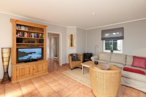 a living room with a couch and a tv at Ferienhaus Buche im Land Fleesensee in Göhren-Lebbin