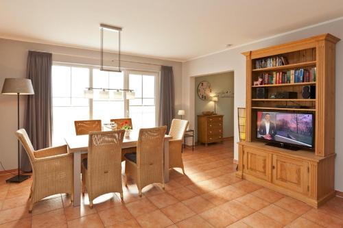 a living room with a dining room table and a television at Ferienhaus Buche im Land Fleesensee in Göhren-Lebbin