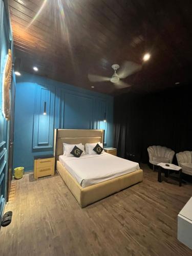 a bedroom with a bed and a blue wall at Palmtree Hotel in Lahore