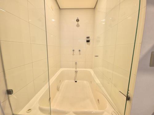 a bath tub with a glass enclosure in a bathroom at Hotel Portal Central in Medellín