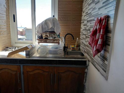 a kitchen with a sink and a window at Résidence Al-amine in Koungou