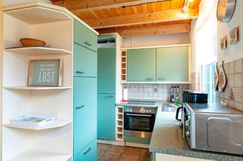 a kitchen with green cabinets and a stove at Ferienhaus Jabel 25 in Jabel