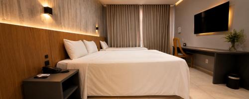 a hotel room with a large bed and a desk at Hotel Del Rey by Poty - RUA XV DE NOVEMBRO in Curitiba