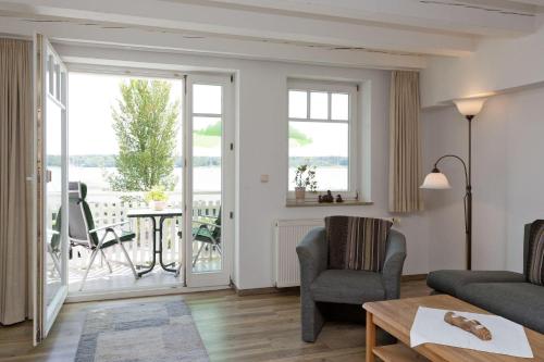 a living room with a couch and chairs and a table at Kietzspeicher App 06 in Waren