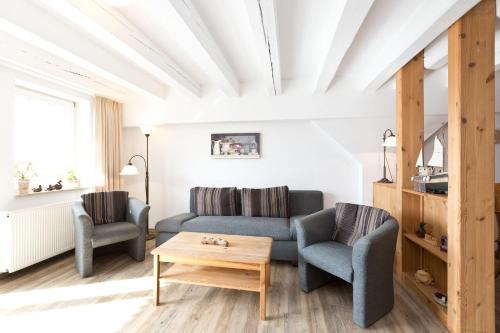 a living room with a couch and two chairs and a table at Kietzspeicher App 06 in Waren