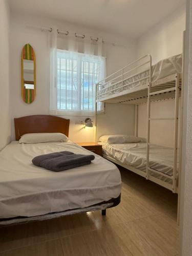 a bedroom with two bunk beds and a window at Magic World Frontal 1ª línea in Oropesa del Mar