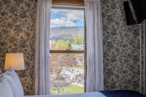 a bedroom with a window with a view of a mountain at The Governor's Inn in Ludlow